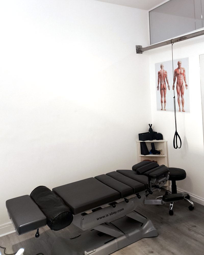 Consultorio de Kinesiarte con camilla de osteopatía, lámina anatómica y equipamiento de terapia manual